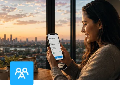 Woman sending money from a payment app on her phone by a city window at sunset